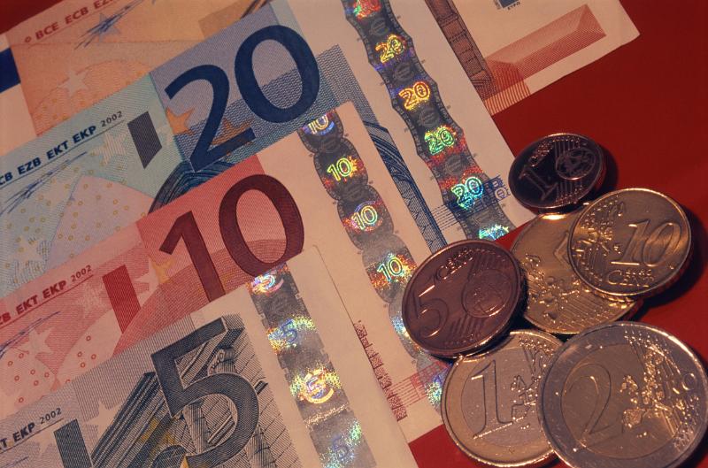 Close Up Still Life of Euro Bills and Coin Currency on Red Background
