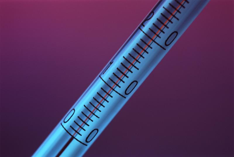 Close up of a thermometer showing the scale on the glass of the tume and the temperature graduations