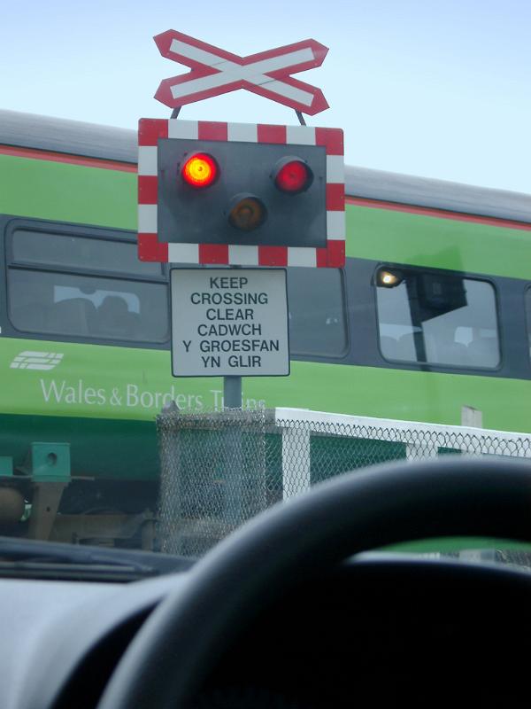Driver Perspective of Car Waiting at Railway Crossing with Signals Flashing for Train to Pass