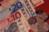 Close Up Still Life of Euro Bills and Coin Currency on Red Background