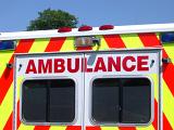 Ambulance viewed from the rear with the colorful red and yellow emergency chevron signage around the doors with the word - Ambulance