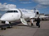 Two Passengers Boarding Small Airplane on Tarmac at Airport