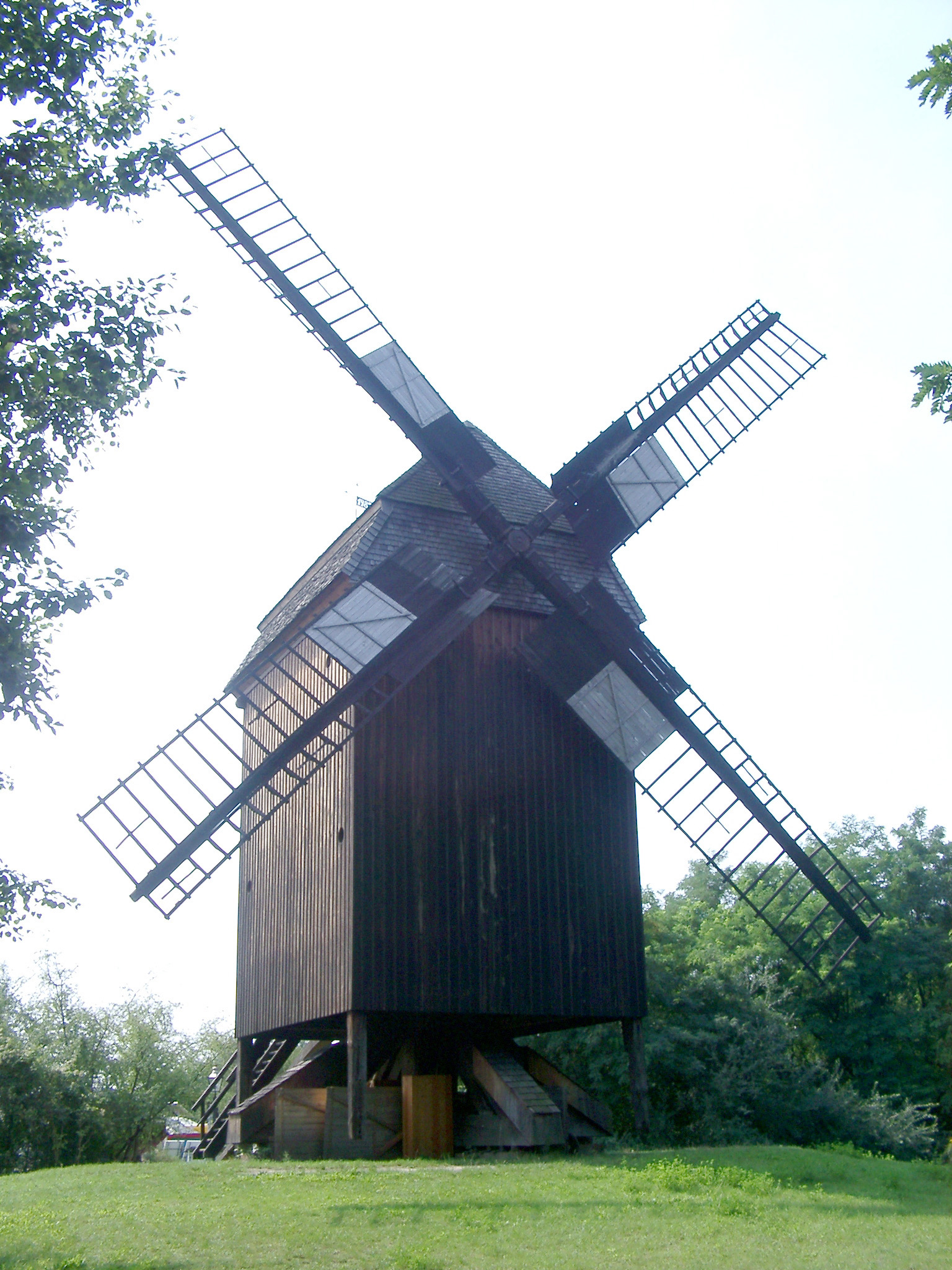 an image of Historic square wooden windmill with large sails in Berlin, now a museum