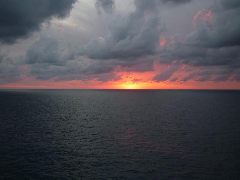 a beautiful pink sunset lights up a stormy sky