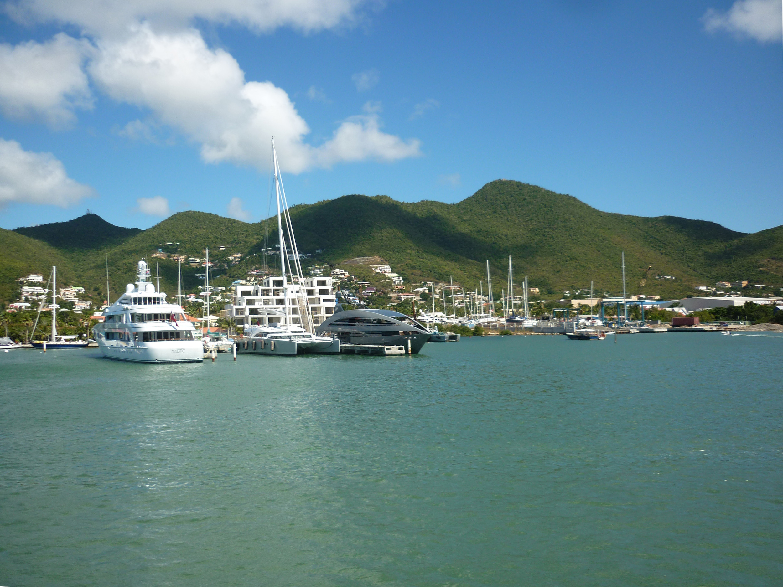 an image of a line of expensive motor yachts, docked at the island of st maarten