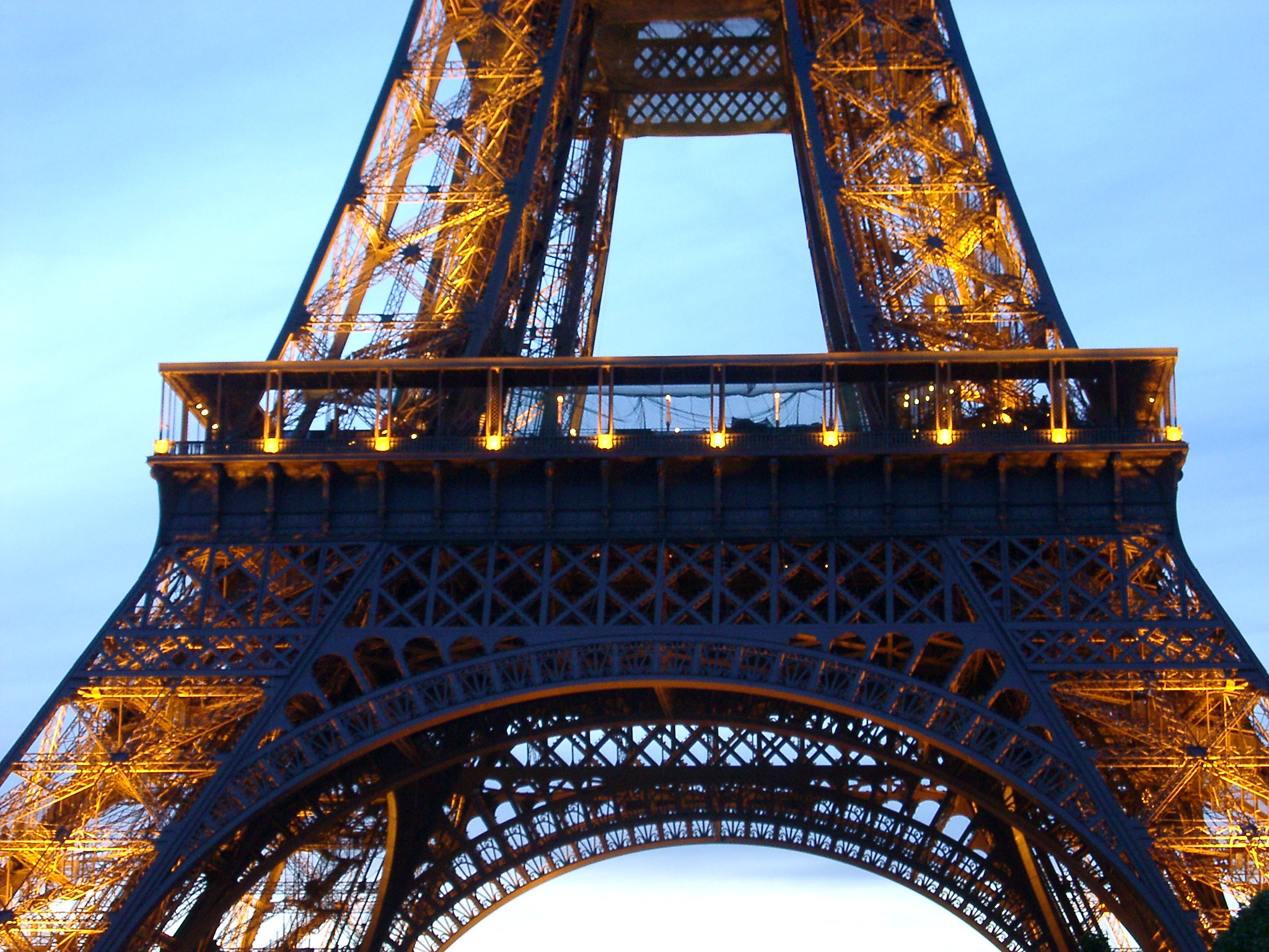an image of Detail of the Eiffel Tower, Paris, France showing the structure of the wrought iron lattice framework of the tower against a blue sky