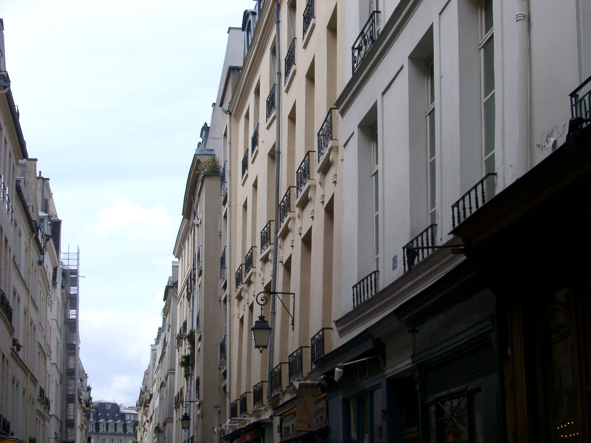 an image of Old Vintage Architecture - Buildings Along Narrow Paris Street. with a Light Blue Sky Background.