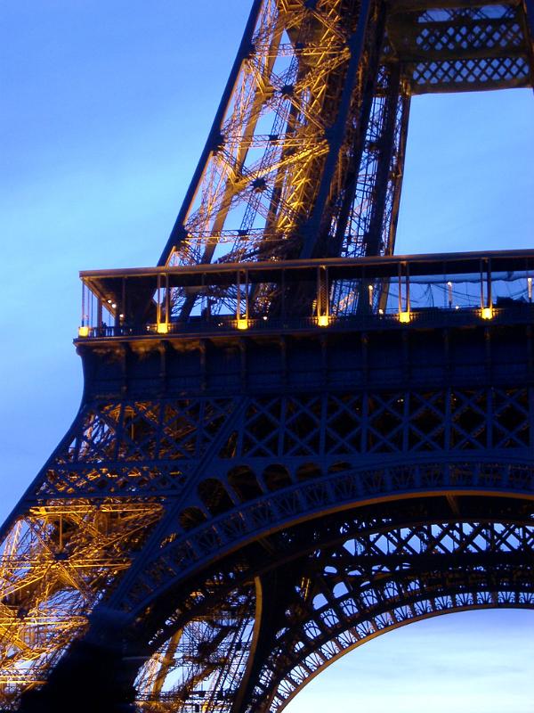 Detail of the lattice framework and iron girders of the Eiffel Tower, Paris against a blue sky