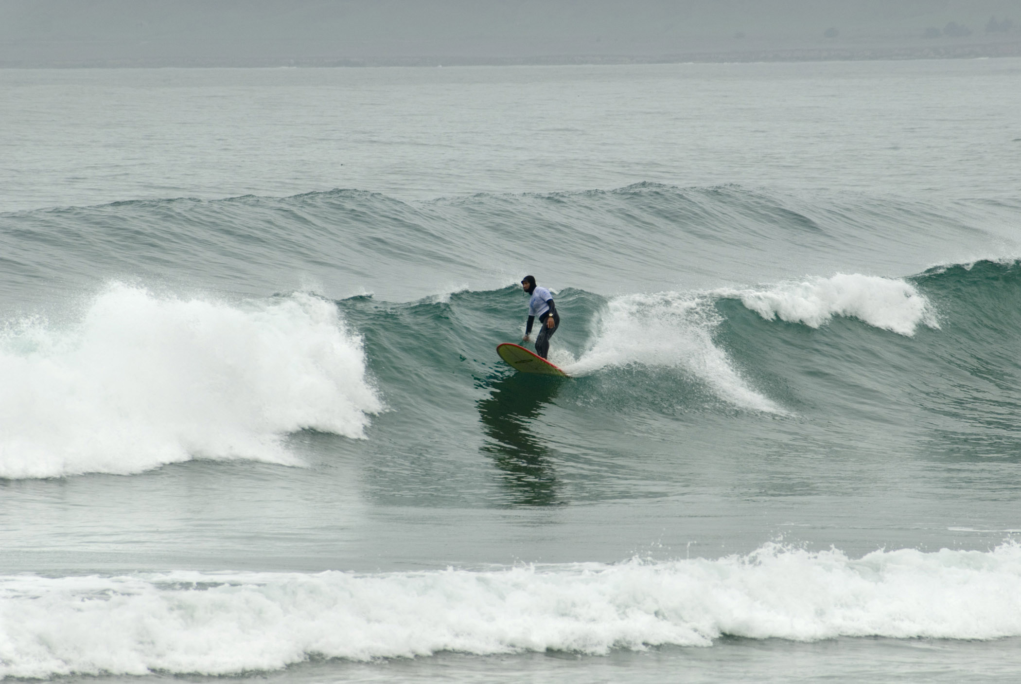 an image of Solo Tourist Winter Surfer at Beautiful Morro Bay. Perfect Place for Vacation.