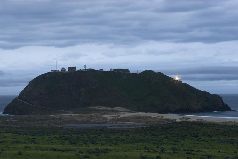 Big Sur Lighthouse on the Point Sur outcrop rumored to be haunted , in early morning light with the beacon shining