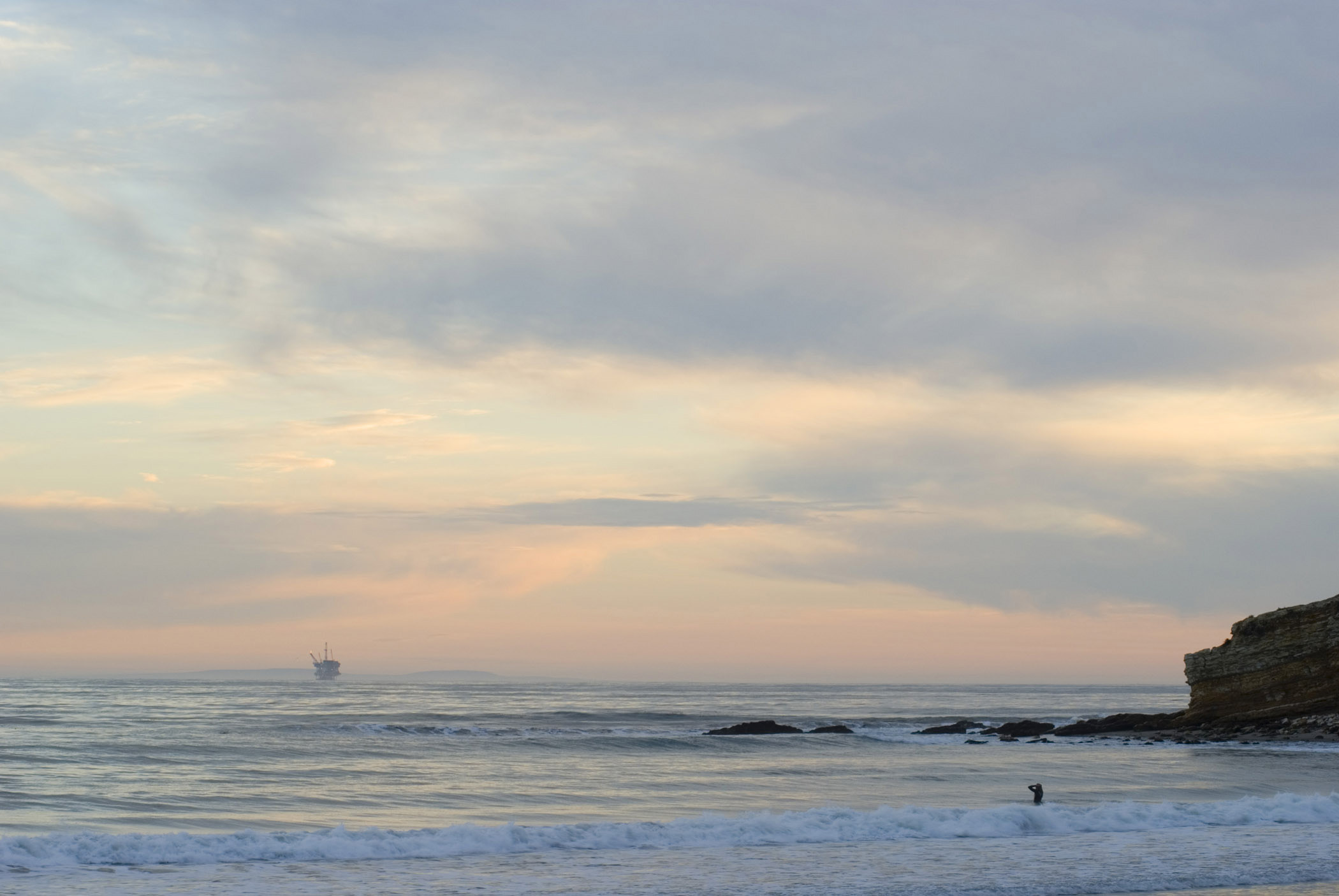 an image of Sunset at Beautiful Refugio Beach in Extensive View. Isolated on Lighter Gray and Orange Sky Background. This Place is Perfect for Vacation.
