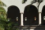 Arched facade decorated with flower pots and tropical palms in Balboa Park, an urban cultural park in San Diego, California,