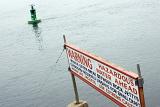 Morro Bay Harbour sign warning of dangerous water ahead for small craft with a buoy in the background