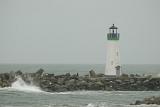 Lighthouse at Rocky Monterey Bay End Located at Santa Cruz Harbor. Isolated on Foggy Sky Background.