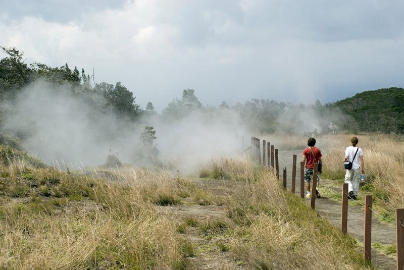 Tourists taking the crater walk in the Volcanoes National Park on Hawaii passing volcanic steam vents
