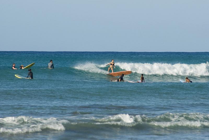 Surfers surfing at Waikiki beach, Hawaii, a favorite tourist destination and surfers paradise