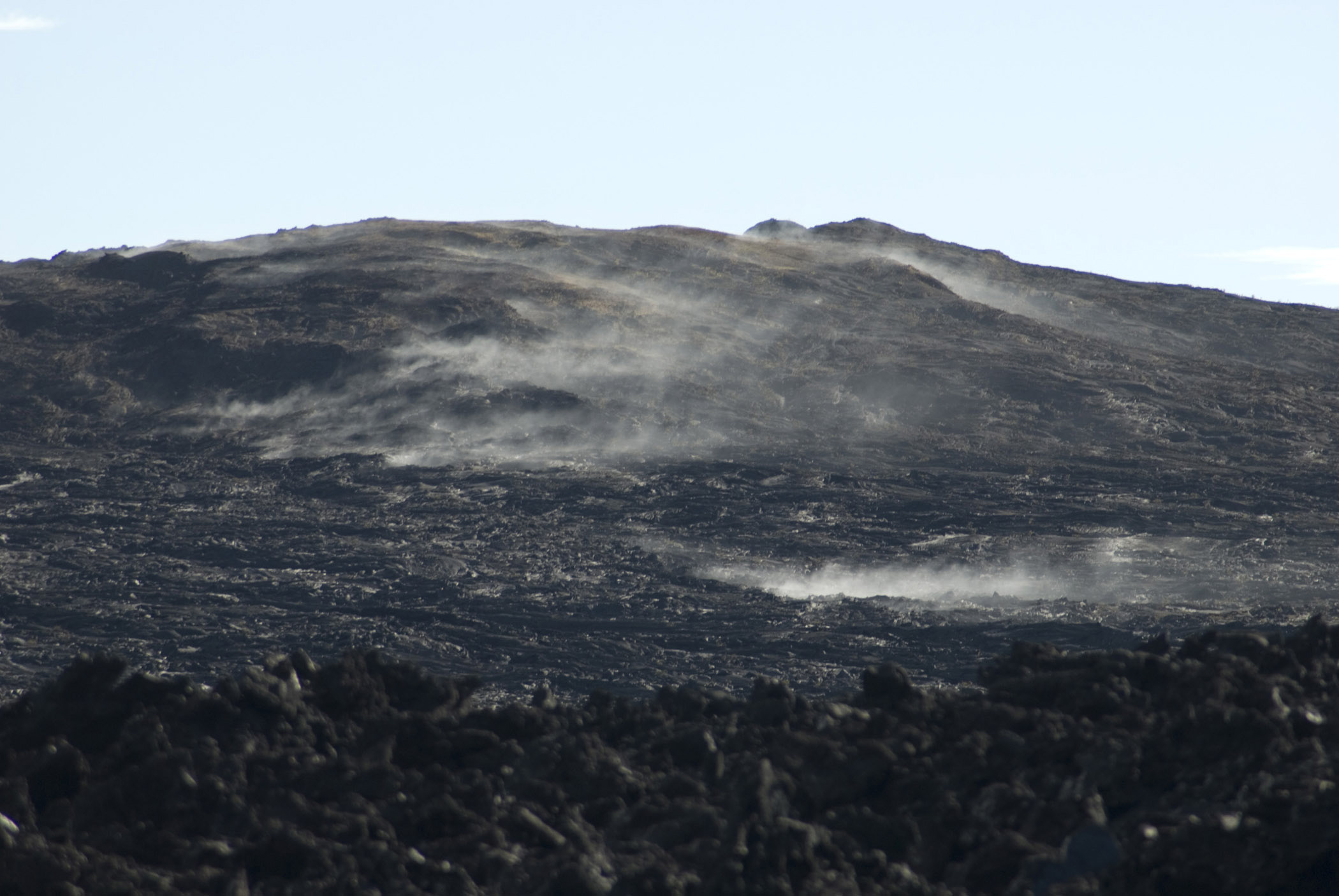 an image of Black volcanic hill of solidified smoking lava in Volcanoes National Park, Hawaii