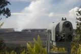 Telescope overlooking the Kikauea Crater with the Haleamaumau crater in the center of the Kilauea caldera releasing smoke and steam - the heart of Kilauea volcano