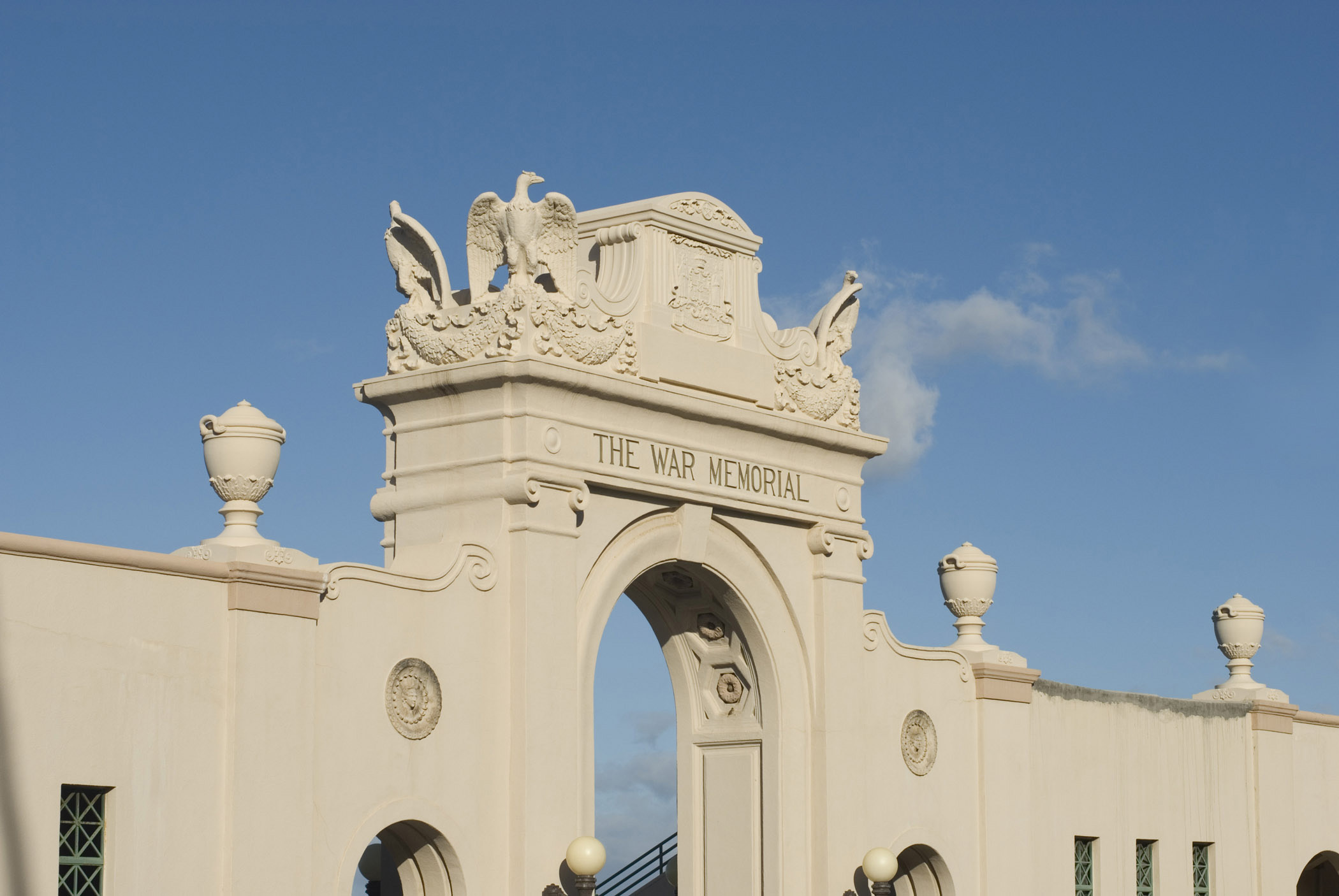 an image of Old Vintage Concrete Arch at Waikiki Natatorium War Memorial in Honolulu. Isolated in Light Blue Sky Background.