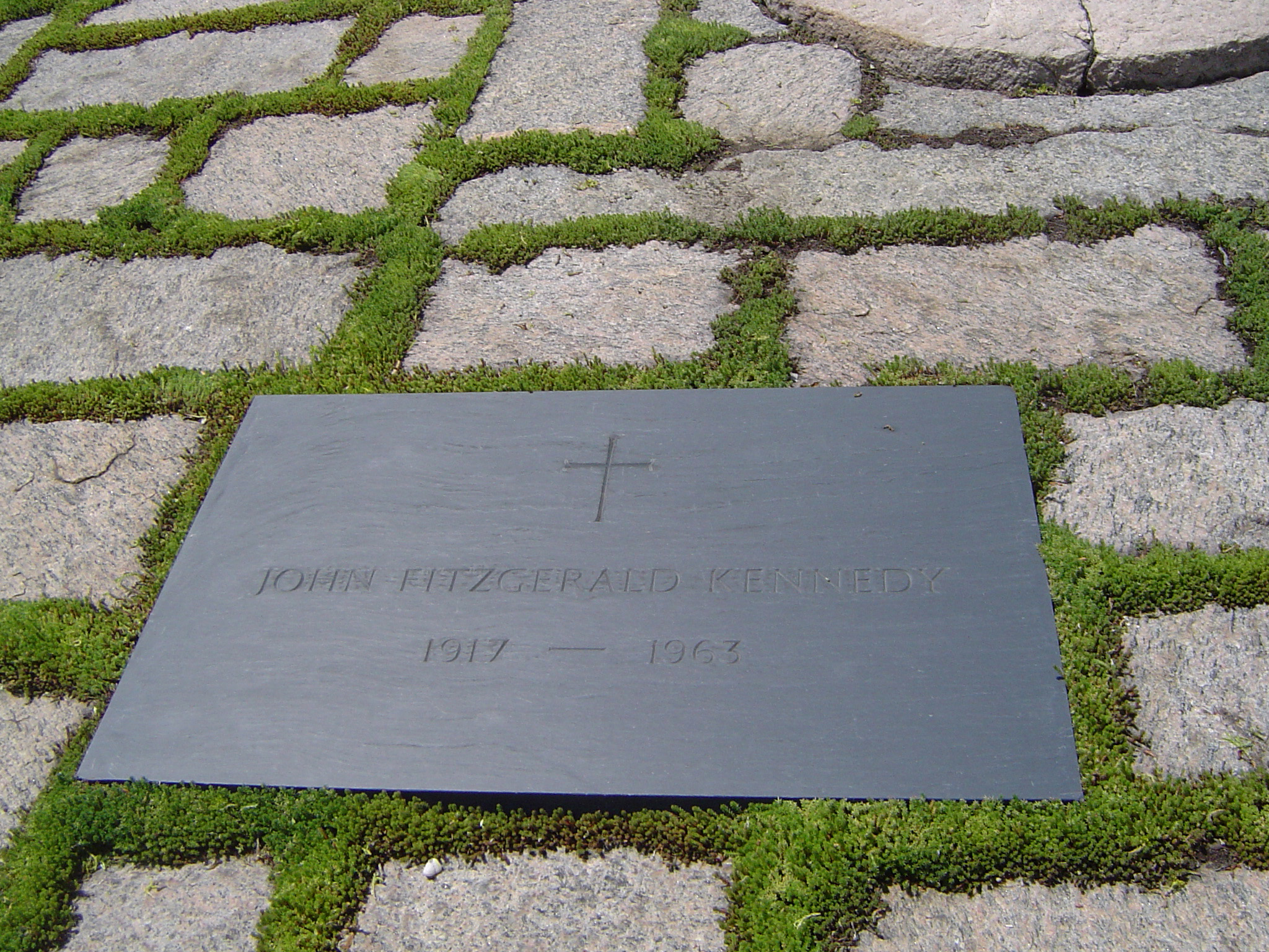 an image of Memorial to John F Kennedy marking the place he was shot with a metal plaque in paving stones