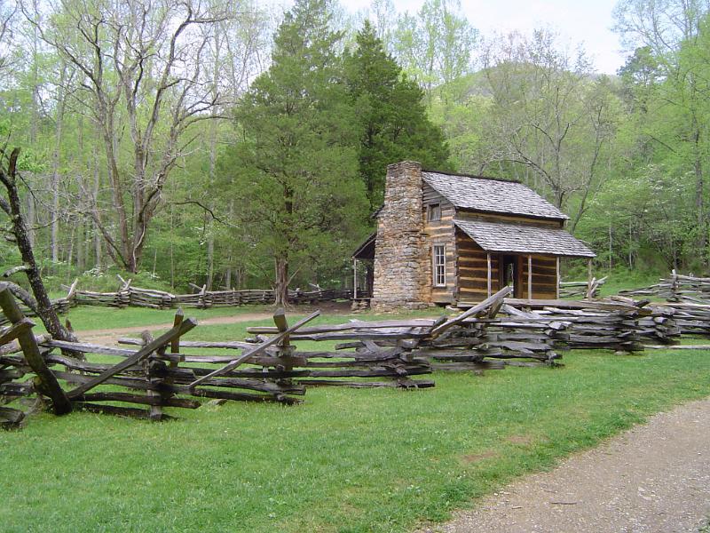 Wooden mountain cabin with a rustic wooden fence in lush woodland, a perfect hideaway for a summer vacation