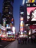 Night scene of the hustle and bustle in Times Square, New York with pedestrians, traffic and brightly colored illuminated neon signs