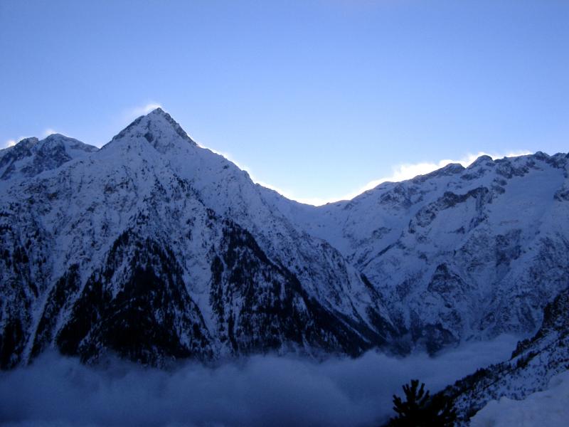 Sunrise Over Snow Covered Huge Mountains on Gradient Light Blue Sky Background.