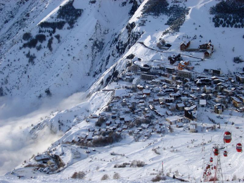 Winter holiday in an alpine village with an aerial view of buildings scattered on a snow covered mountain slope