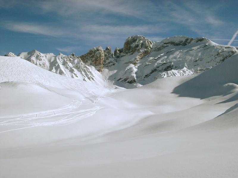 Nice View of Fresh Snow on Field and Mountains During Winter Season. Captured with Lighter Blue Sky Background.