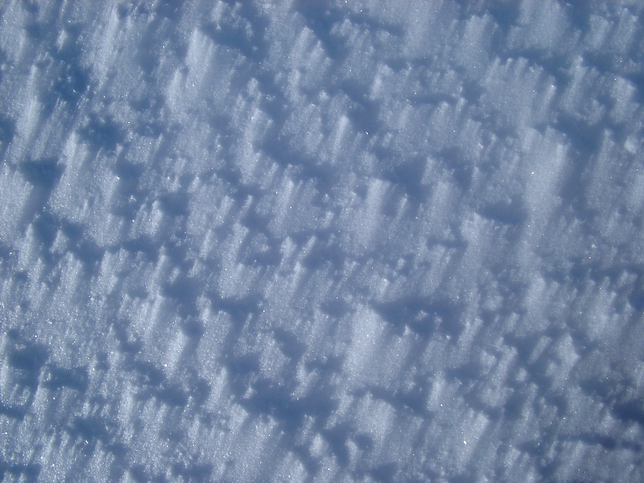 an image of Textured Wind Blown Ice Snow on Ground During Winter Holiday Season.