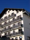 Architectural Alpine Lodge Building Exterior Design on Blue Sky Background.